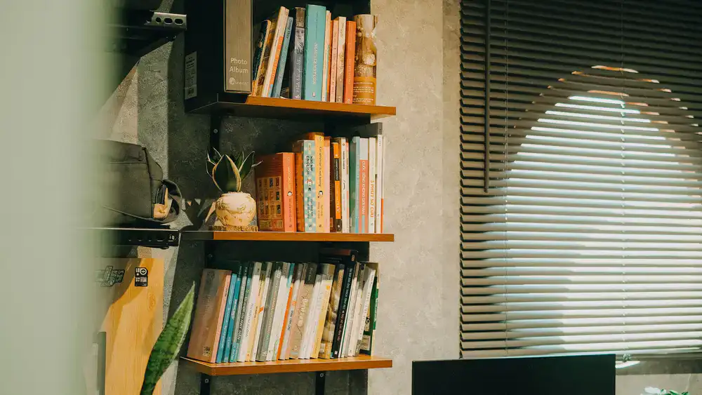 A cozy, warmly lit developer workspace with sketchbooks and plants